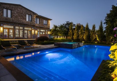 Backyard with lights on in swimming pool
