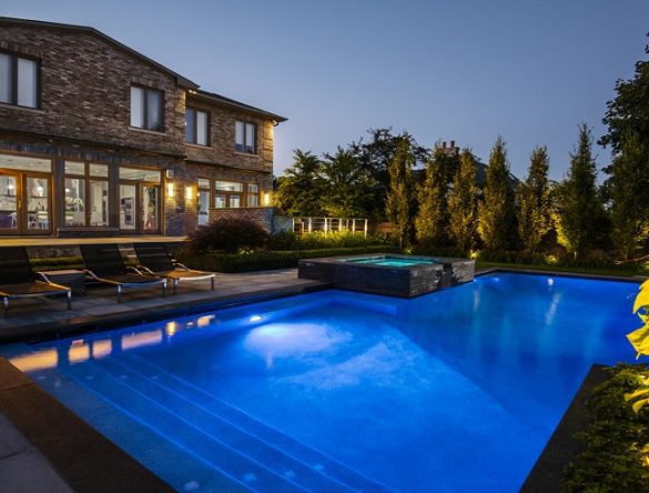Backyard with lights on in swimming pool