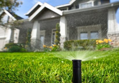 Sprinkler head watering front yard of house