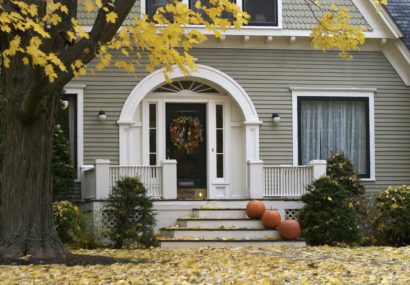 Suburban house prepared for fall with leaves falling around